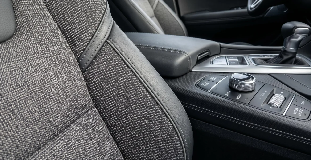 Gros plan sur la texture de la sellerie et des matériaux du tableau de bord d'une Renault Clio 5, éclairage naturel latéral